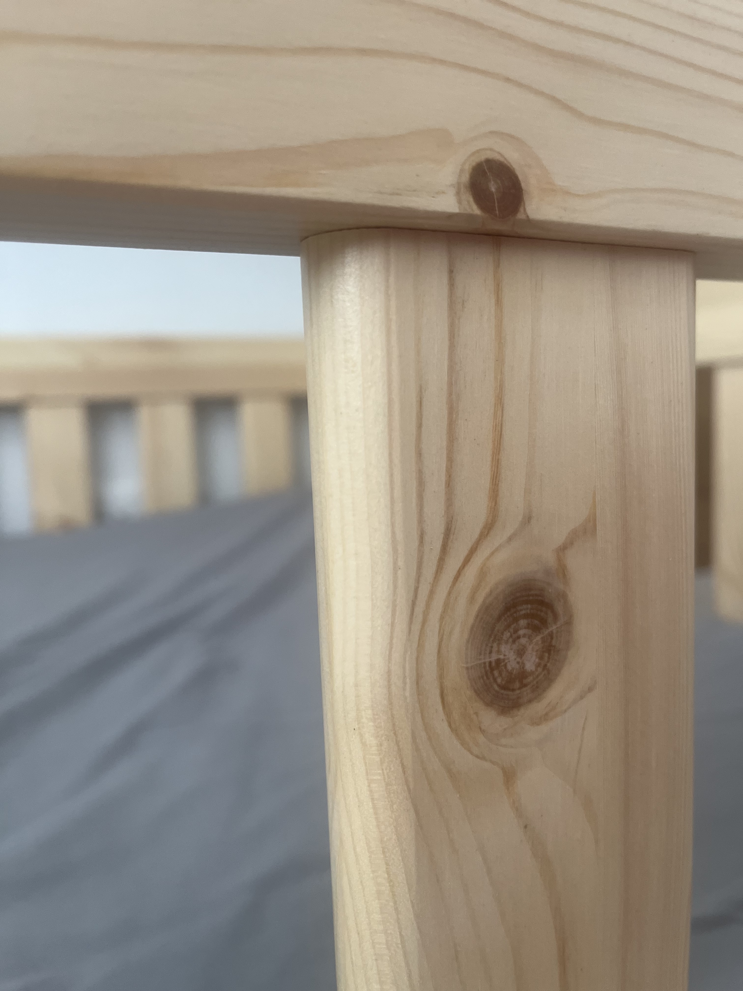 Close-up of the Roomix Transition Toddler Bed pine finish